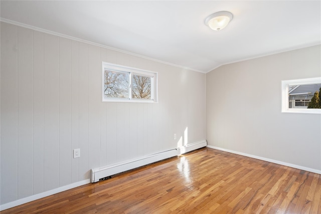 spare room with lofted ceiling, hardwood / wood-style flooring, crown molding, and baseboard heating