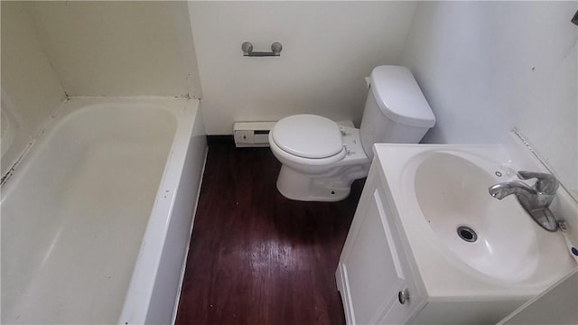 bathroom with vanity, a baseboard heating unit, a bath, hardwood / wood-style floors, and toilet