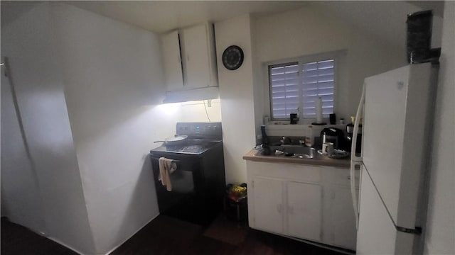 kitchen with white cabinets, washer / dryer, and white fridge