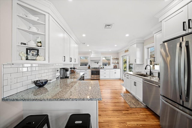 kitchen featuring kitchen peninsula, sink, white cabinets, and appliances with stainless steel finishes