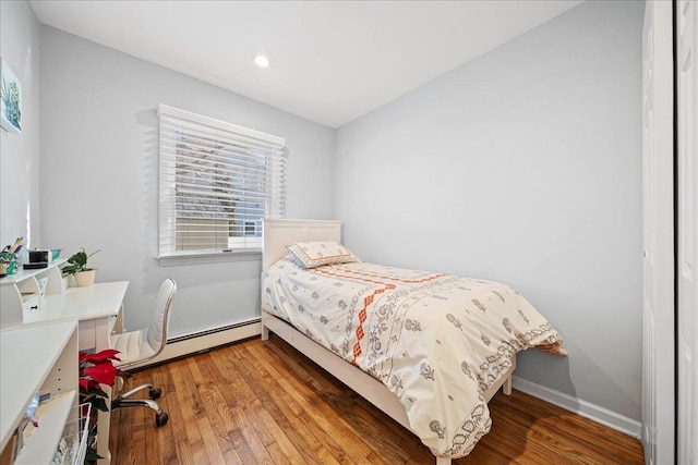 bedroom with wood-type flooring and a baseboard radiator