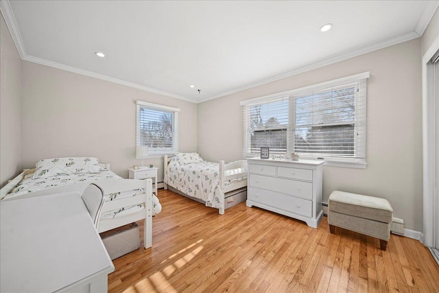 bedroom featuring multiple windows, ornamental molding, and light wood-type flooring