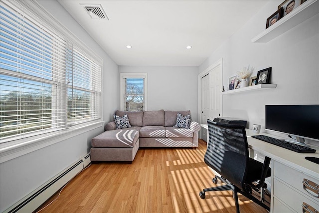 office with a healthy amount of sunlight, light wood-type flooring, and a baseboard radiator