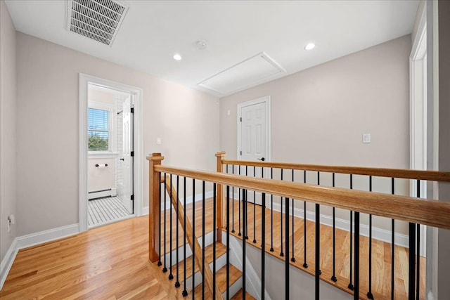 hall with a baseboard radiator and light hardwood / wood-style floors