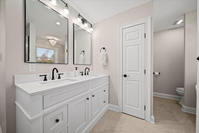 bathroom with tile patterned flooring, vanity, and toilet