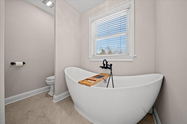 bathroom featuring tile patterned floors, a bathtub, and toilet