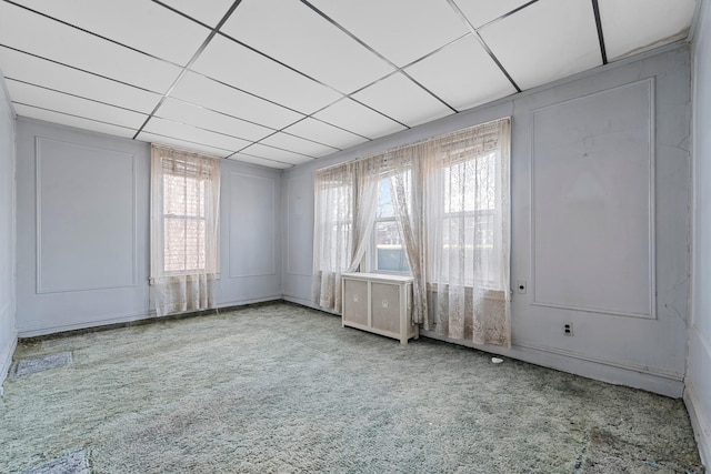 carpeted spare room featuring a paneled ceiling