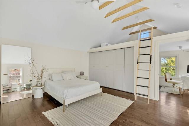 bedroom with vaulted ceiling with beams, a closet, ceiling fan, and dark wood-type flooring