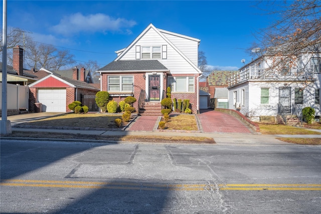 view of front of house featuring a garage and an outbuilding