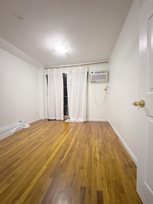 unfurnished room featuring light hardwood / wood-style floors and a wall mounted air conditioner