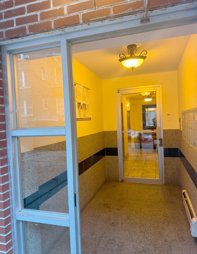 hall with tile walls and a baseboard radiator