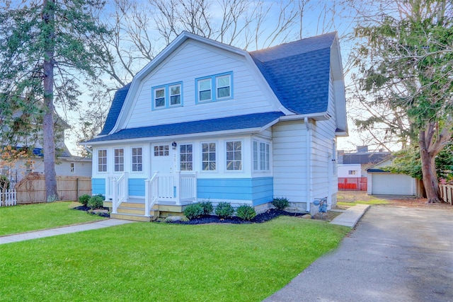 view of front of home with an outbuilding, a front yard, and a garage