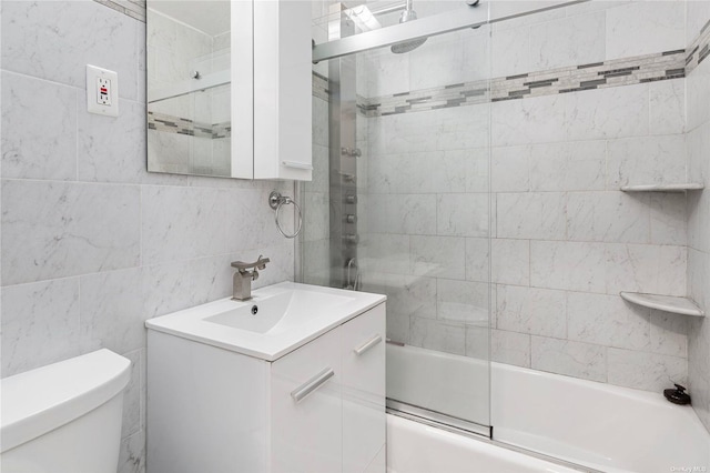 full bathroom with decorative backsplash, bath / shower combo with glass door, vanity, tile walls, and toilet