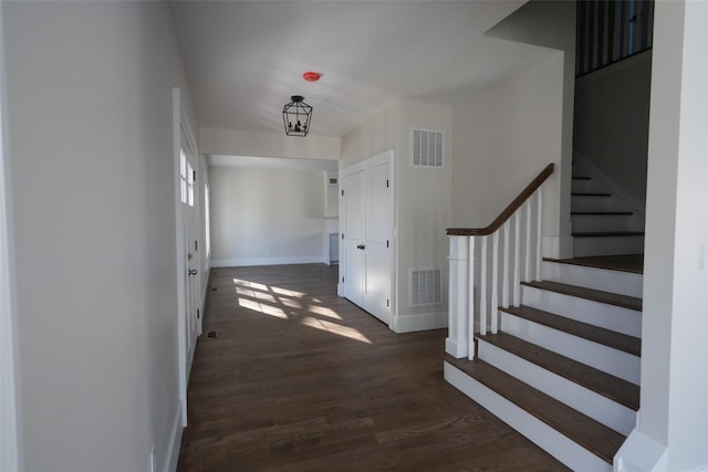 interior space with dark wood-type flooring and a chandelier