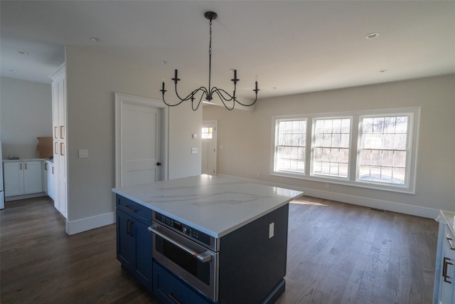 kitchen featuring stainless steel oven, dark wood-type flooring, pendant lighting, a chandelier, and a center island