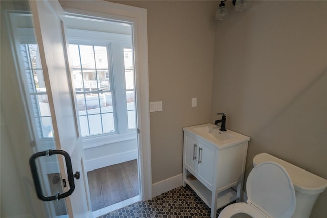 bathroom featuring vanity, toilet, and a healthy amount of sunlight