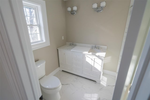 bathroom featuring plenty of natural light, toilet, and vanity