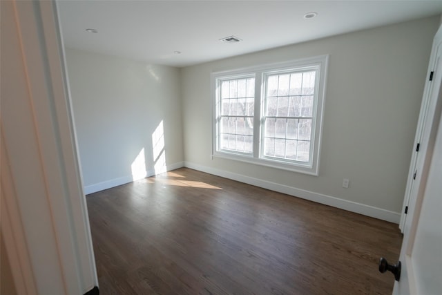 spare room with dark hardwood / wood-style flooring