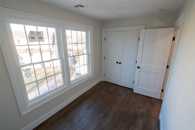 unfurnished bedroom featuring dark hardwood / wood-style floors and a closet