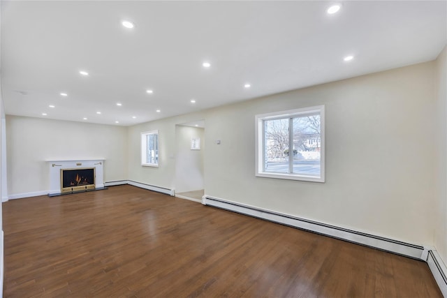 unfurnished living room with hardwood / wood-style flooring and a baseboard radiator