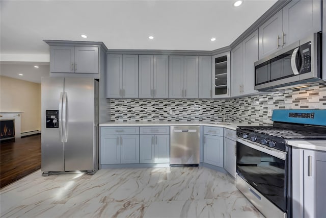 kitchen with decorative backsplash, gray cabinetry, stainless steel appliances, sink, and a baseboard radiator