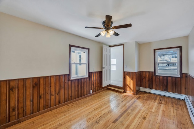 unfurnished room with ceiling fan, light hardwood / wood-style floors, and a baseboard radiator