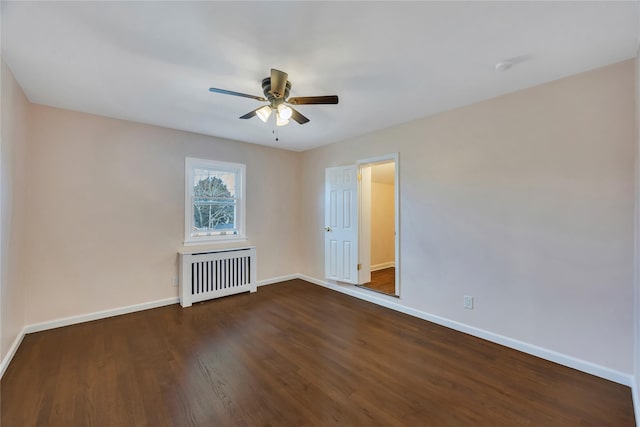 unfurnished room featuring dark hardwood / wood-style floors, ceiling fan, and radiator