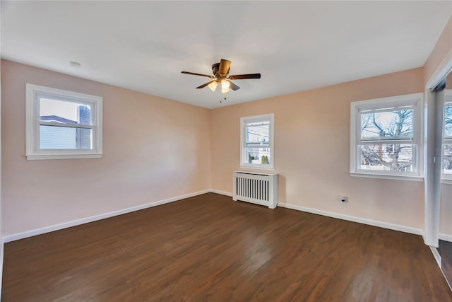 unfurnished living room featuring dark hardwood / wood-style flooring, radiator, a healthy amount of sunlight, and ceiling fan