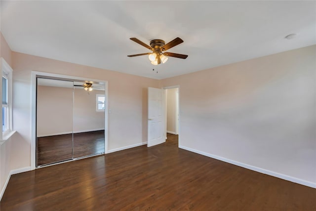 unfurnished bedroom featuring ceiling fan, dark wood-type flooring, and a closet