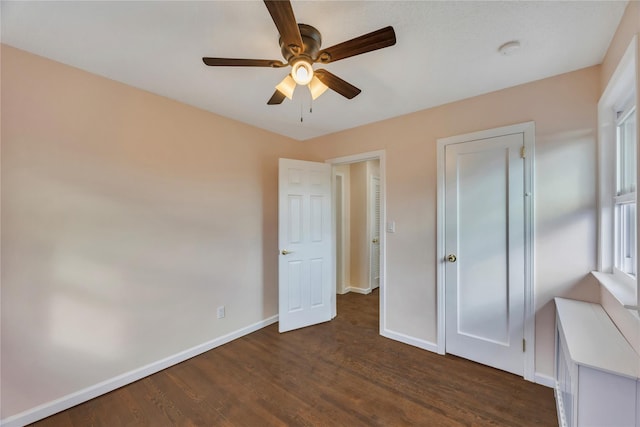 unfurnished bedroom featuring dark hardwood / wood-style floors and ceiling fan