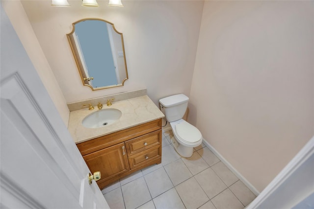 bathroom with toilet, vanity, and tile patterned floors