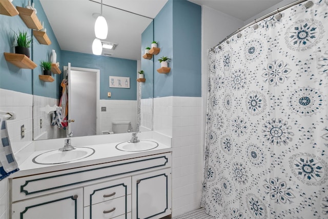 bathroom featuring tile walls, toilet, walk in shower, and vanity