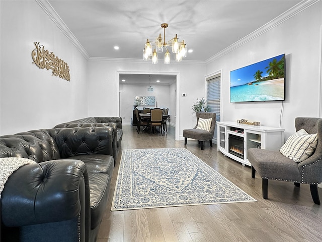 living room with wood-type flooring, crown molding, and a chandelier