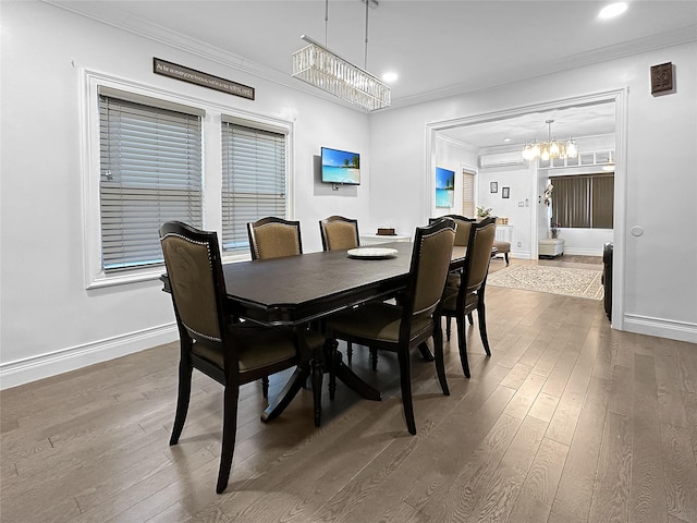 dining space with dark hardwood / wood-style flooring, crown molding, a wall unit AC, and an inviting chandelier