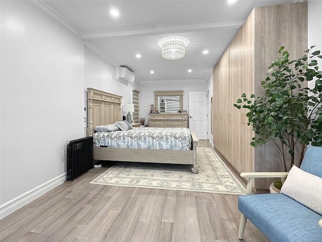 bedroom with light hardwood / wood-style floors, crown molding, a wall unit AC, and a chandelier