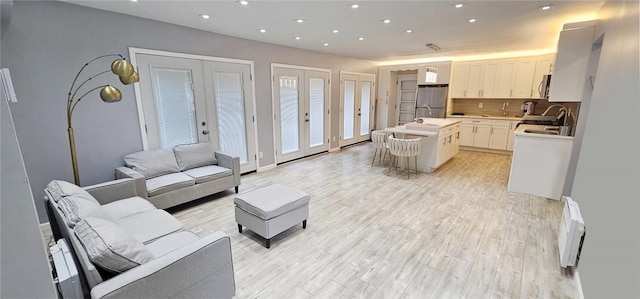 living room featuring french doors and light hardwood / wood-style flooring