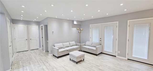 living room with light wood-type flooring and french doors