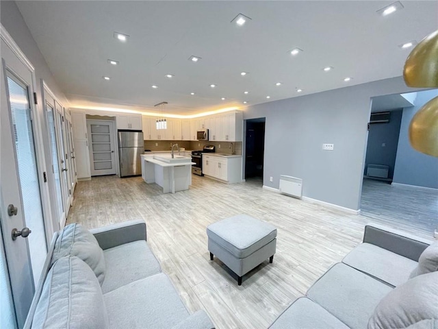 living room with light wood-type flooring and sink