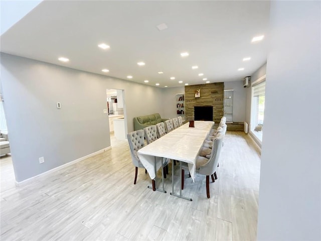 dining room with light hardwood / wood-style flooring and a fireplace