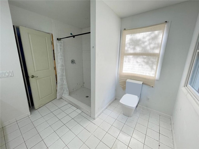 bathroom featuring toilet, a shower with shower curtain, and a wealth of natural light