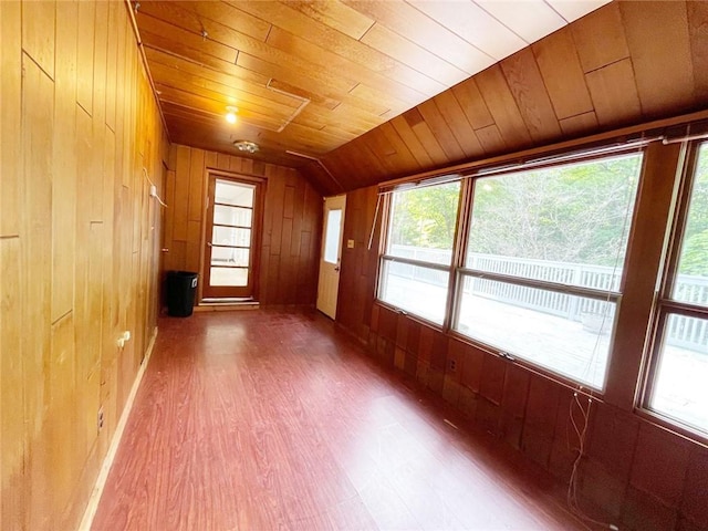 additional living space with wooden walls, vaulted ceiling, and wood ceiling