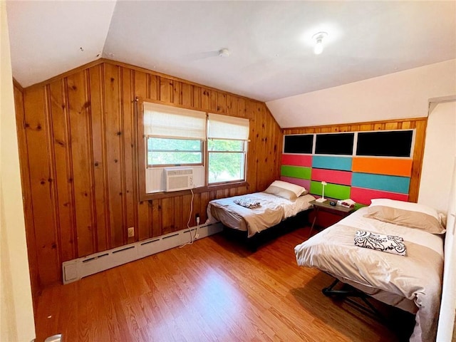 bedroom with a baseboard heating unit, vaulted ceiling, cooling unit, and hardwood / wood-style flooring