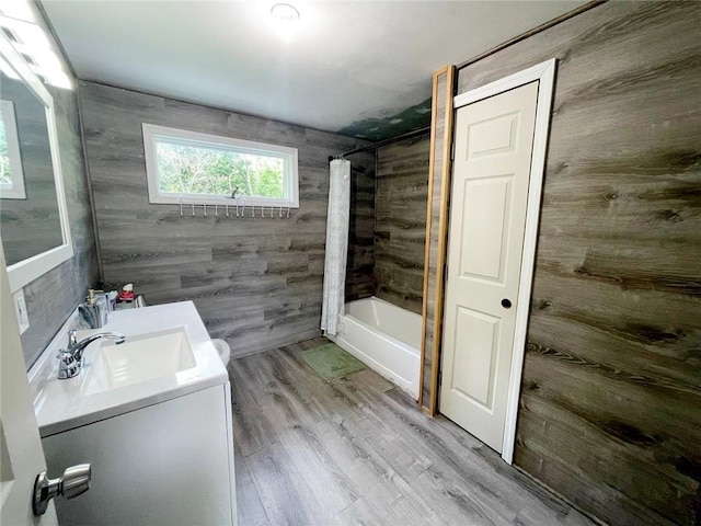 bathroom featuring vanity, shower / bathtub combination with curtain, and hardwood / wood-style flooring