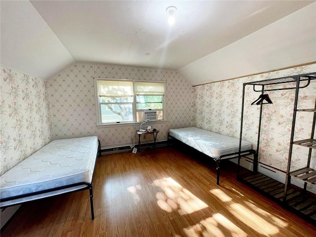 bedroom featuring lofted ceiling, baseboard heating, and hardwood / wood-style floors