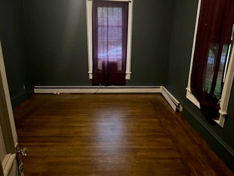 spare room featuring dark hardwood / wood-style flooring and baseboard heating