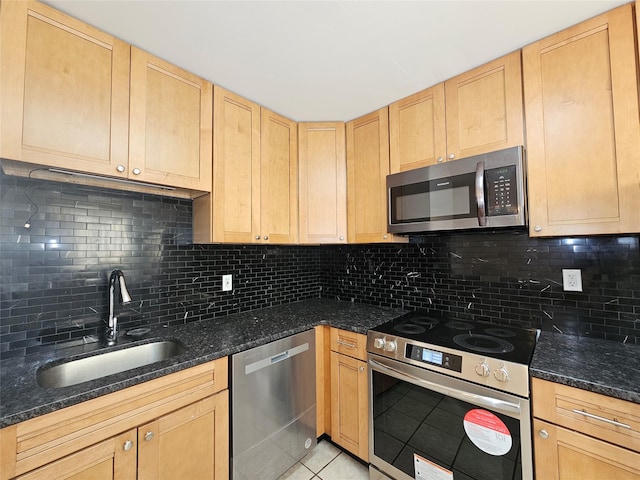 kitchen with stainless steel appliances, dark stone counters, and tasteful backsplash