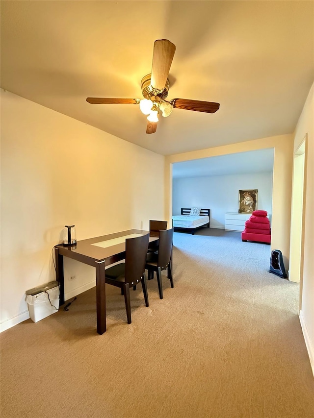 carpeted dining space with ceiling fan