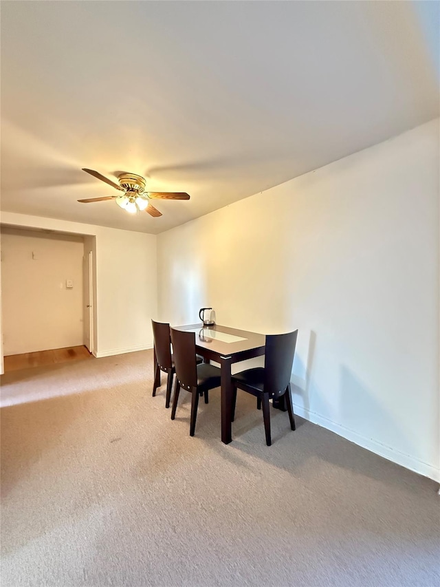 carpeted dining room featuring ceiling fan