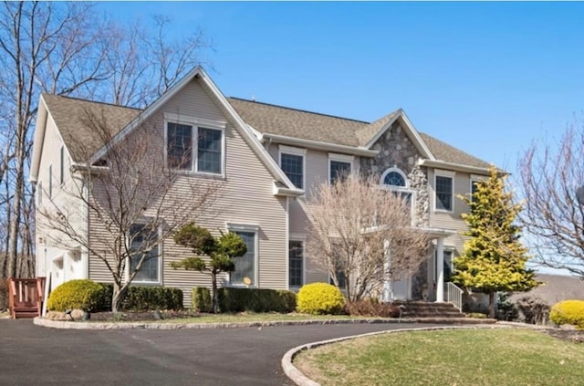 colonial inspired home with a front lawn