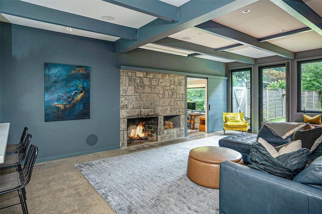 living room with a healthy amount of sunlight, baseboards, beam ceiling, and a stone fireplace